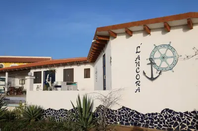 a building with a sign on the side of it at L' Ancora - Room With Exclusive Pool And Terrace in Palmeira