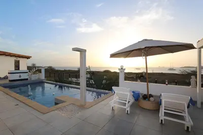 a swimming pool with two chairs and an umbrella at L' Ancora - Room With Exclusive Pool And Terrace in Palmeira