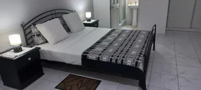 a bedroom with a large bed and a night stand at Ka-Bela 2 in Sal Rei