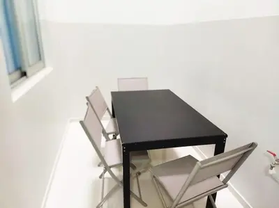 a black table with two white chairs next to it at Apto Morabeza T2 Praia in Praia