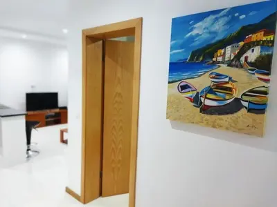 a painting of a beach with boats on a wall at Apto Morabeza T2 Praia in Praia