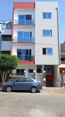 a blue car parked in front of a building at Apto Morabeza T2 Praia in Praia