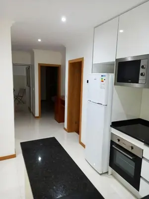 a kitchen with a white refrigerator and a stove at Apto Morabeza T2 Praia in Praia