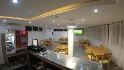 a restaurant with a bar and tables and chairs at Hotel São Jorge village in Órgãos