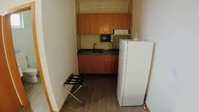 a kitchen with a white refrigerator in a room at Hotel São Jorge village in Órgãos
