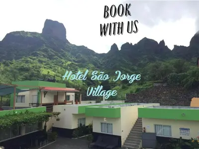 a book with us with mountains in the background at Hotel São Jorge village in Órgãos