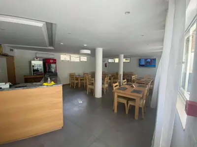 a restaurant with wooden tables and chairs and a counter at Hotel São Jorge village in Órgãos
