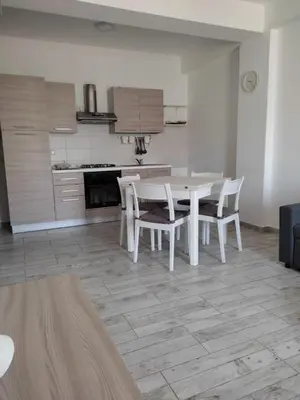 a white kitchen with a white table and chairs at Ca'Claudia Boavista in Sal Rei