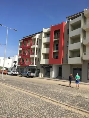 two people standing on a street in front of a building at Ca'Claudia Boavista in Sal Rei