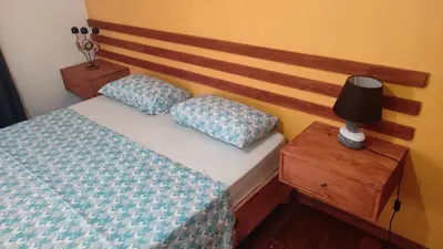 a bedroom with a bed with a wooden head board at Rose`s place in Mindelo