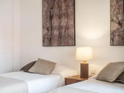 two beds in a room with a lamp and pictures on the wall at Casa da Djedja in Mindelo