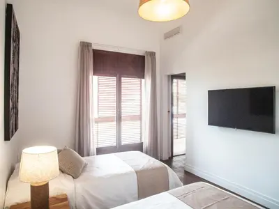 a bedroom with two beds and a flat screen tv at Casa da Djedja in Mindelo