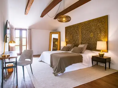 a bedroom with a large bed and a table and chair at Casa da Djedja in Mindelo
