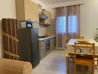 a small kitchen with a table and a refrigerator at Ca GIOgió in Santa Maria