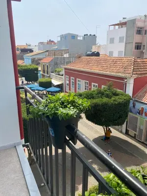 a balcony with two potted plants on a railing at Amilcar Cabral Loft in Praia