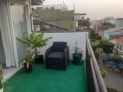 a balcony with a chair and potted plants at Christian Place in Praia