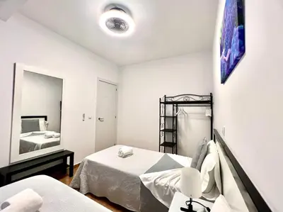 a white room with two beds and a mirror at DAISAL APARTMENT - 2 bedroom apartment with balcony near the beach & city center in Santa Maria