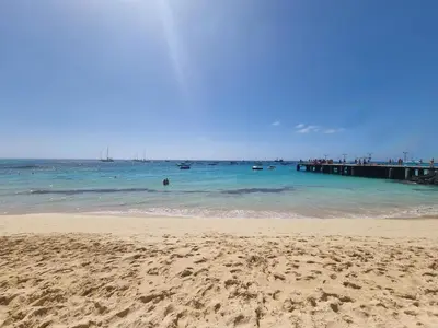 a beach with a pier and boats in the water at DAISAL APARTMENT - 2 bedroom apartment with balcony near the beach & city center in Santa Maria