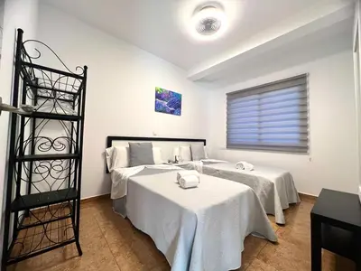 a room with two beds with white sheets at DAISAL APARTMENT - 2 bedroom apartment with balcony near the beach & city center in Santa Maria