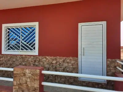 a house with two windows and a stone wall at Guest House Maio in Vila do Maio