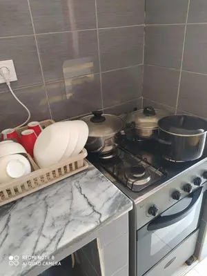 a kitchen counter with a stove with pots and pans at Guest House Maio in Vila do Maio