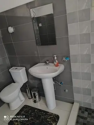 a bathroom with a sink and a toilet and a mirror at Guest House Maio in Vila do Maio