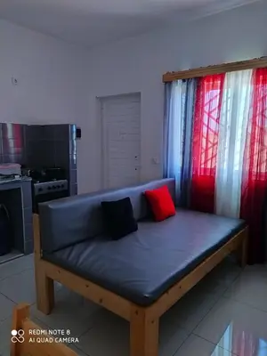 a blue couch with two red pillows in a kitchen at Guest House Maio in Vila do Maio