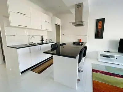 a kitchen with white cabinets and a black counter top at Duarte Apartments - Laginha in Mindelo