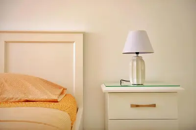 a lamp on a night stand next to a bed at Duarte Apartments - Laginha in Mindelo
