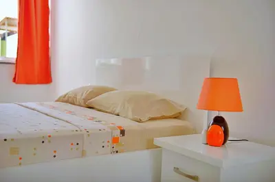 a bedroom with a bed and a table with a lamp at Duarte Apartments - Laginha in Mindelo