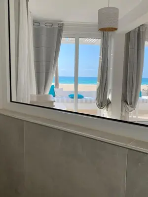 a view of the ocean from a room with a mirror at Villa Nº25b Alfredo Marchetti suites on the beach Praia di Chaves in Cabeçadas