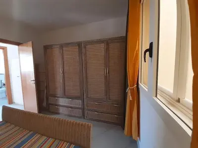a room with wooden shutters on the wall and a window at App Raffaele Estoril Beach Free Wifi & AC a step away from the sea in Sal Rei