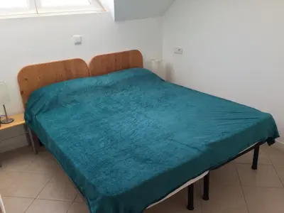 a bed with a green blanket on it in a room at Leme Bedje GST84 3 bedroom apt with Panaramic views in Santa Maria