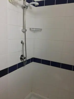 a bathroom with a shower with blue and white tiles at Leme Bedje GST84 3 bedroom apt with Panaramic views in Santa Maria