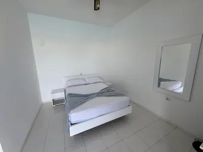 a white room with a bed and a mirror at Académico do Sal in Espargos