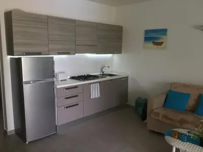 a small kitchen with a stove and a refrigerator at Apt14 Porto Antigo 1 with Pool and Beach views in Santa Maria