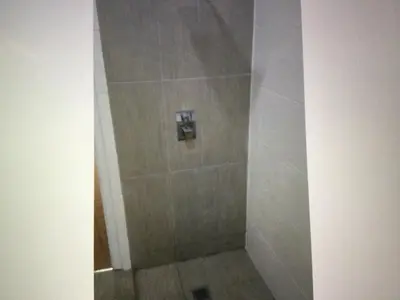 a shower in a bathroom with a tiled floor at Apt14 Porto Antigo 1 with Pool and Beach views in Santa Maria