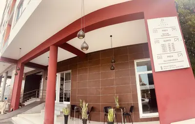 a building with red pillars and a restaurant with chairs at Hotel Vista in Praia