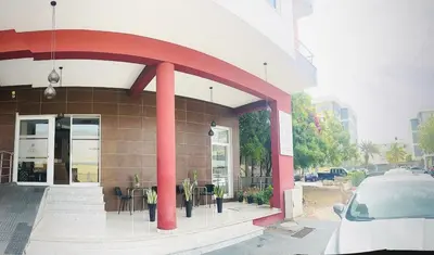 a building with red columns and tables in front of it at Hotel Vista in Praia