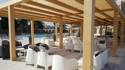 a pavilion with white chairs and tables and a pool at Oasis Praiamar in Praia