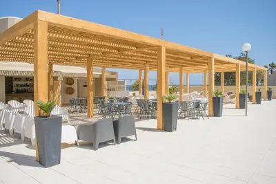 a pavilion with tables and chairs on a patio at Oasis Praiamar in Praia