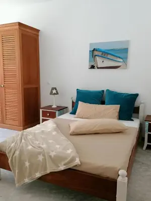 a bedroom with a large bed with blue pillows at Villa Pescadora spectacular view, luxery fisherhouse design in Sal Rei
