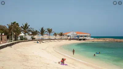 a group of people in the water on a beach at Beach Townhouse - Murdeira Village in Beirona