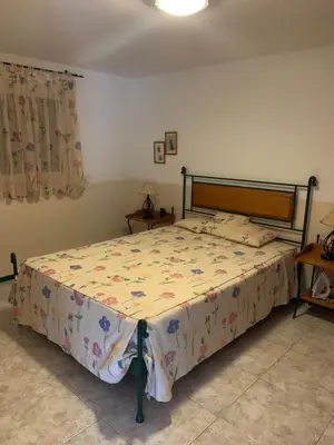 a bedroom with a bed with a floral bedspread at Beach Townhouse - Murdeira Village in Beirona