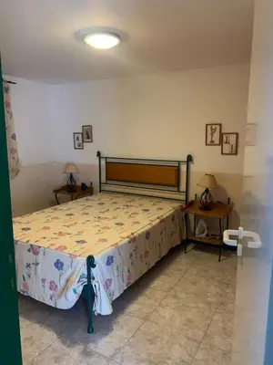 a bedroom with a bed and two tables with lamps at Beach Townhouse - Murdeira Village in Beirona