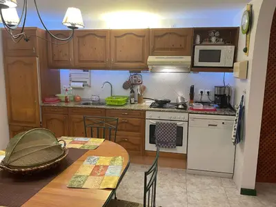 a kitchen with wooden cabinets and a table at Beach Townhouse - Murdeira Village in Beirona
