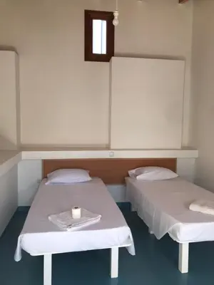 two beds in a hospital room with a cup on a tray at Quintal do Maio in Vila do Maio