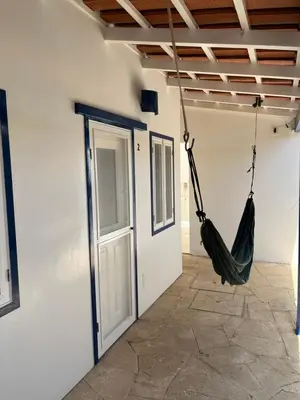 a hammock hanging in a room with a door at Quintal do Maio in Vila do Maio