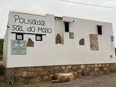 a white building with a sign that reads pueblo san do mao at Quintal do Maio in Vila do Maio
