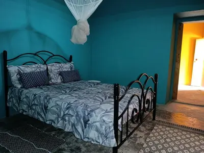 a bed in a room with a blue wall at Ecolodge Ribeira Principal in Xá Xá